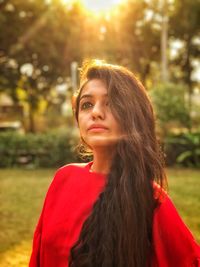 Portrait of young woman looking away while standing outdoors