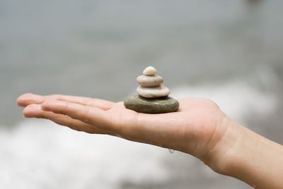 Close-up of human hand stacking pebbles at beach