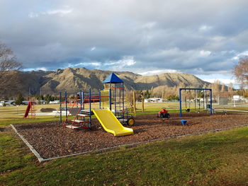 Children playing on grass against sky