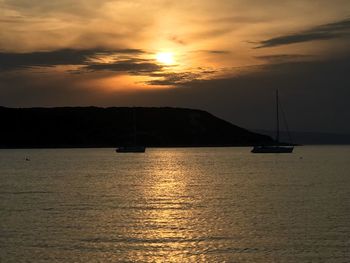 Sailboat sailing on sea against sky during sunset