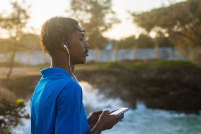 Young man using mobile phone at the beach