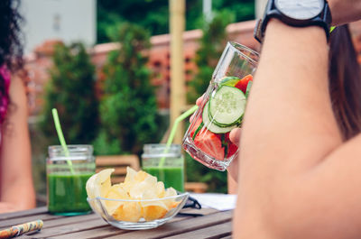 Cropped hand of woman having drink on table