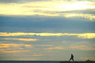 Scenic view of sea against cloudy sky during sunset