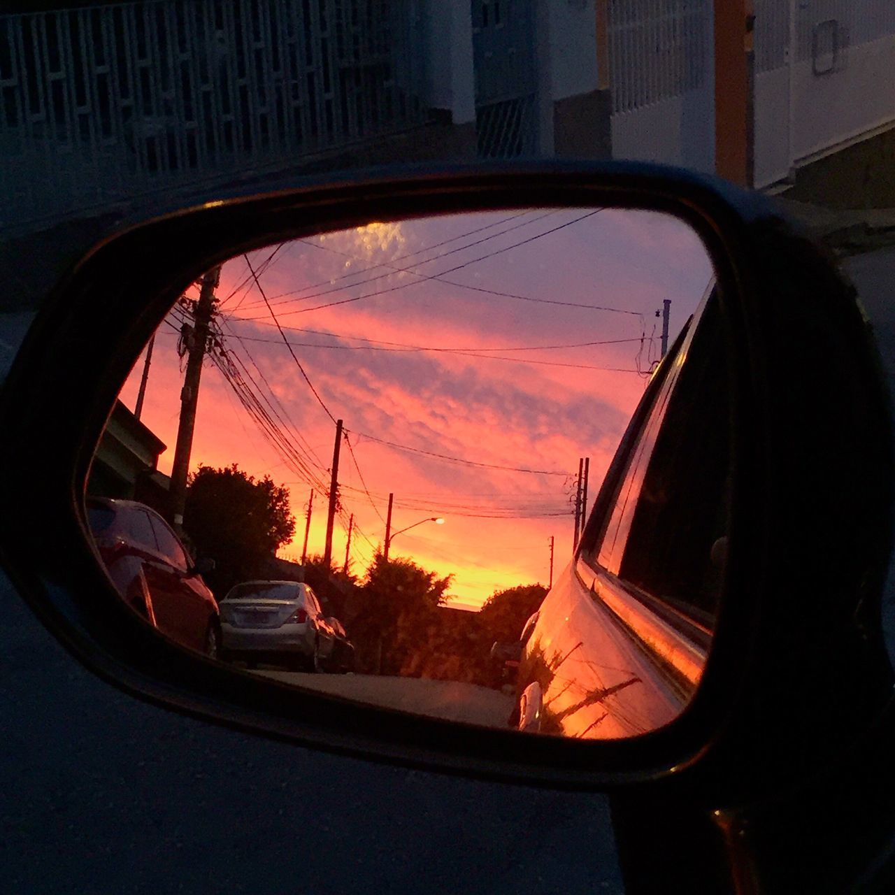 CLOSE-UP OF CAR SIDE-VIEW MIRROR AGAINST CLOUDY SKY