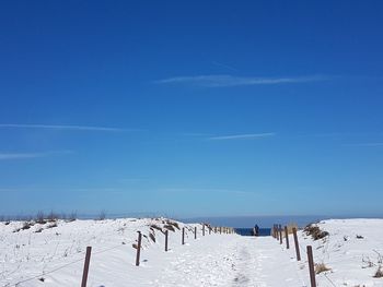 Scenic view of snow covered field against sky