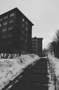 Empty road along buildings in winter