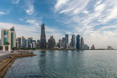 Modern buildings in city against cloudy sky