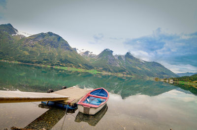 Scenic view of lake and mountains against blue sky