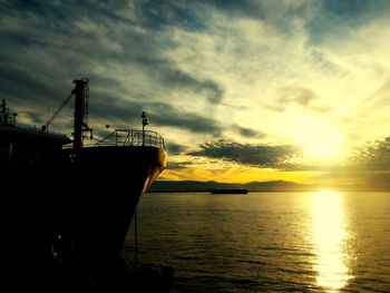 Silhouette sailboats in sea against sky during sunset