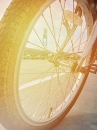 Close-up of bicycle wheel against yellow wall