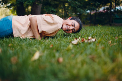 Boy lying on grass in field