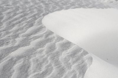 Low section of man relaxing on sand