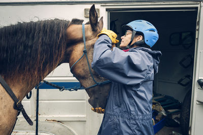 Female doctor examining horse while standing by ambulance