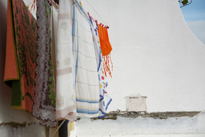 Low angle view of clothes drying against white wall