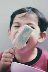 Close-up portrait of boy licking ice cream