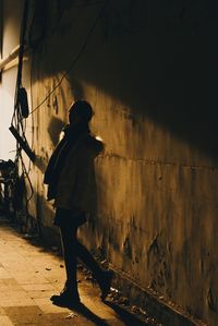 Side view of silhouette woman standing on street at night