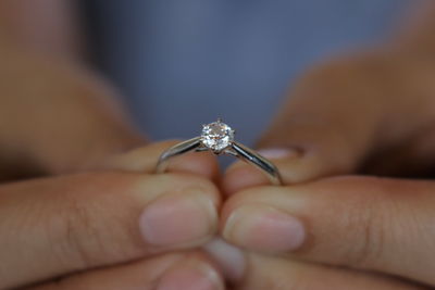 Cropped hand of person holding wedding ring