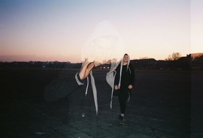 Digital composite image of man standing on field against sky