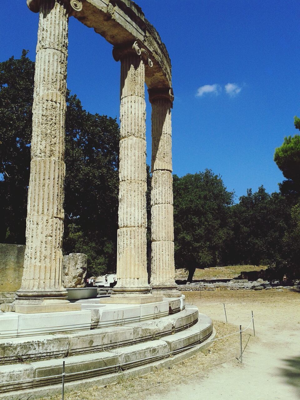 built structure, architecture, history, architectural column, famous place, blue, building exterior, tree, sky, travel destinations, monument, clear sky, tourism, the past, old ruin, sunlight, travel, column, old, low angle view