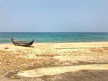 Boat on beach against clear sky