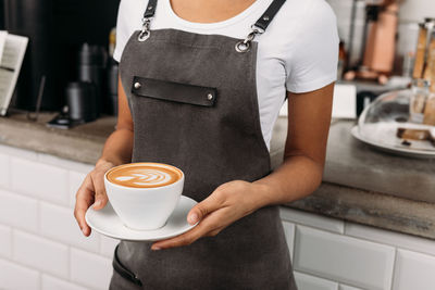 Midsection of woman holding coffee