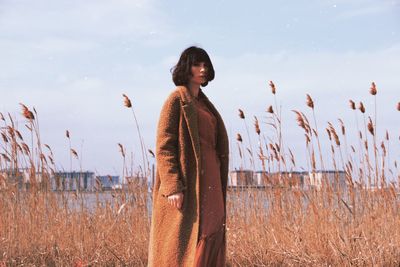 Woman standing on field against sky