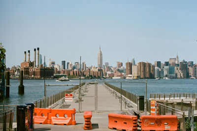 City at waterfront against clear sky