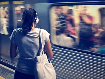 Rear view of woman on station platform.