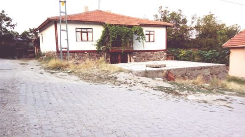 Houses by street against sky in city