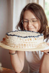 Portrait of young woman holding coffee at home