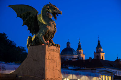 Low angle view of statue of building against blue sky