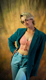 Portrait of young woman standing against wall