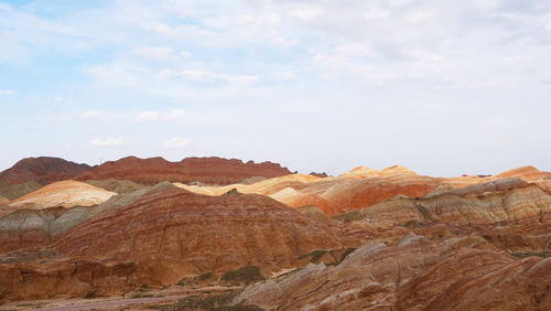 Rock formations on landscape against cloudy sky