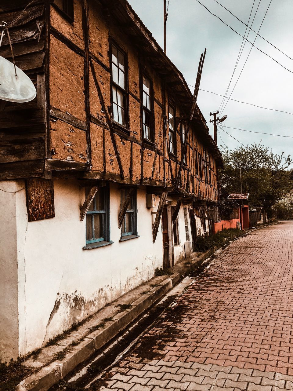 architecture, built structure, building exterior, building, sky, house, day, residential district, no people, nature, window, direction, city, street, old, transportation, the way forward, cable, outdoors, cobblestone, electricity, roof tile, power supply