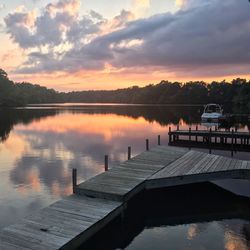 Pier over lake against sky during sunset