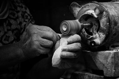 Cropped hands of mature woman operating machinery in darkroom