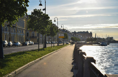 Street by buildings in city against sky