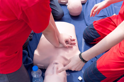 Volunteers giving first aid training with mannequin