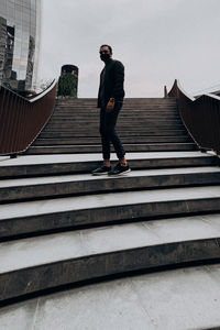 Low angle view of man standing on staircase against building