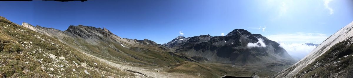 Panoramic view of snowcapped mountains against blue sky