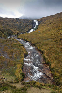 Scenic view of waterfall against sky