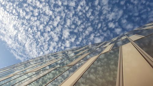 Low angle view of glass building against sky