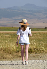 Rear view of woman standing on field