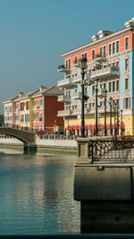 Buildings by swimming pool in city against clear sky