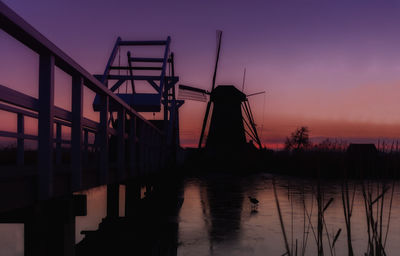 Traditional windmill on field during sunset