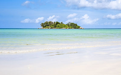 Single tropical island with blue sky and turquoise water, seychelles