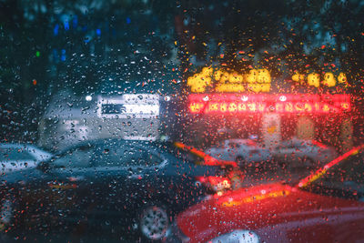 Cars on road seen through wet window during rainy season