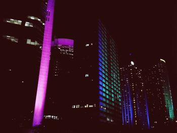 Low angle view of illuminated skyscrapers against sky at night