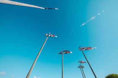 Low angle view of airplane flying against clear blue sky