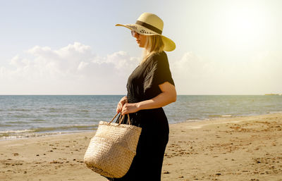 Man wearing hat on beach against sky